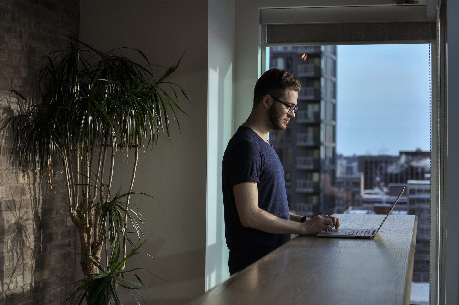 a man using a laptop while standing