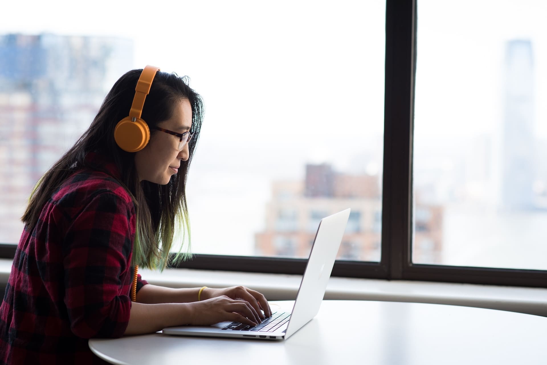 a woman using a laptop near a window