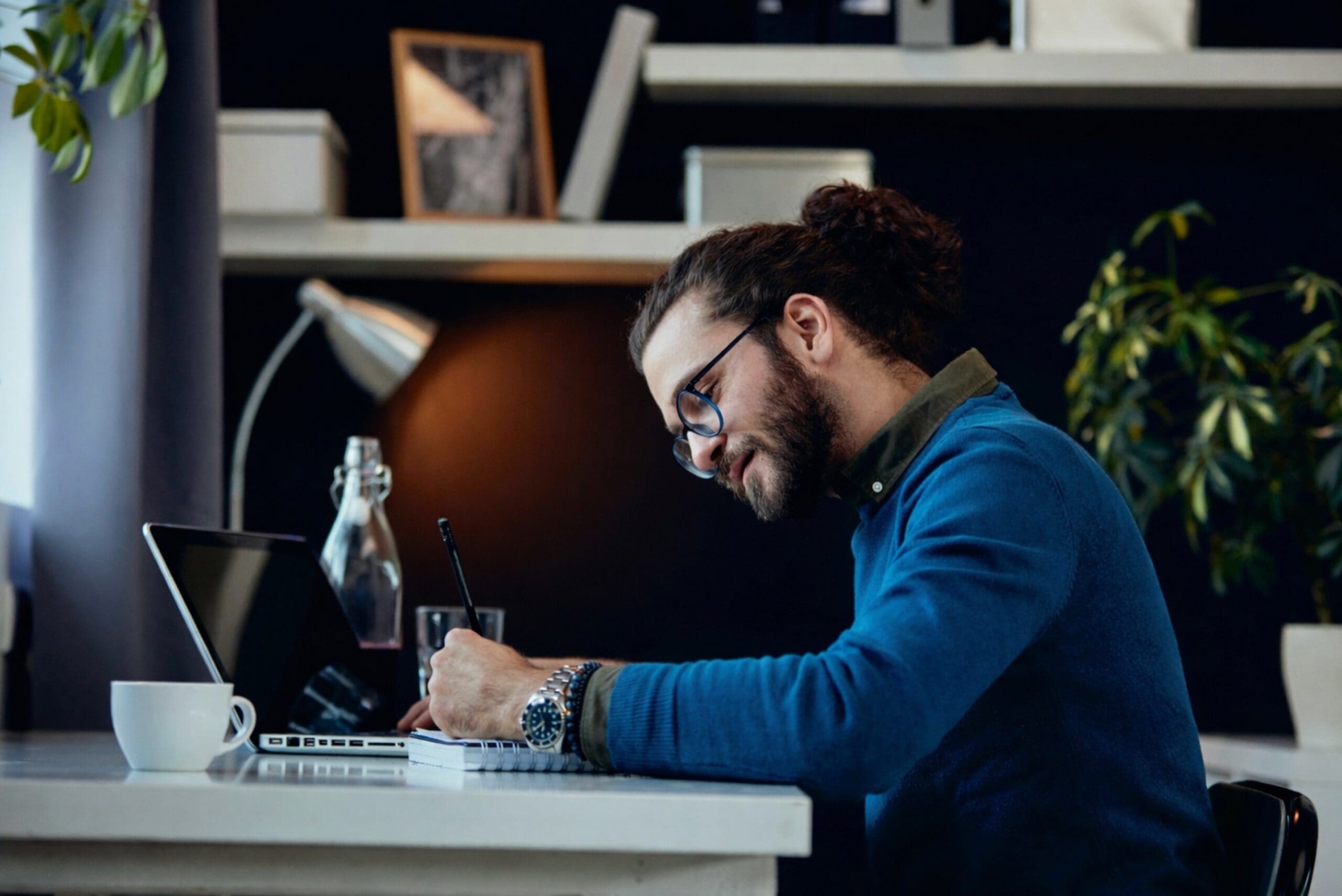 Man writing at desk in office setting